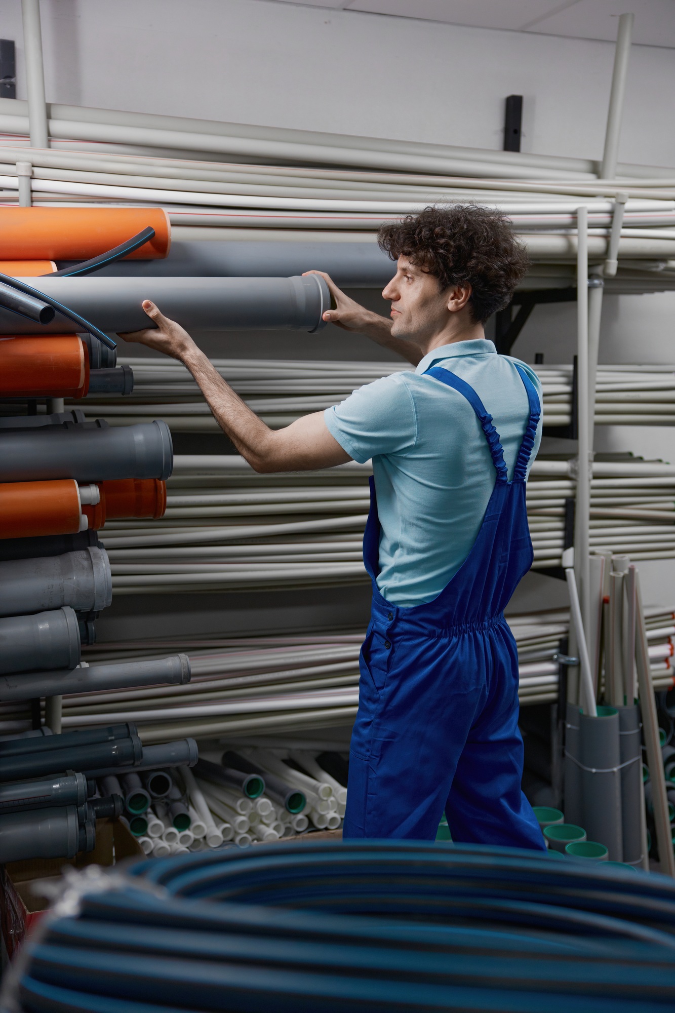 Man plumber choosing supplies for pipework at plumbing shop